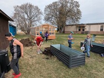 Students hauling dirt to planters